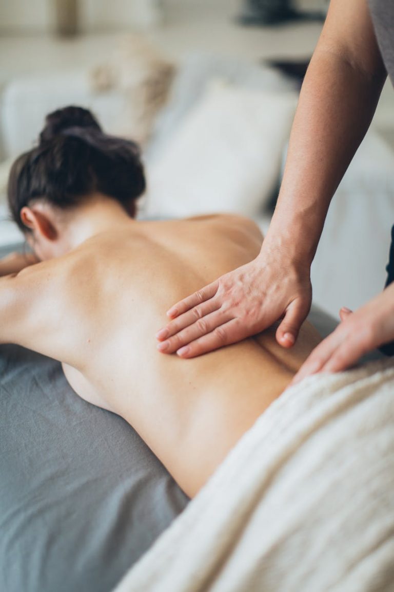 topless woman lying on bed for a massage